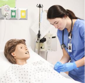 Nursing student working with a medical mannequin